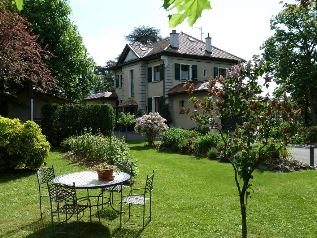 un tavolo e sedie nel cortile di una casa di Domaine du Pressoir ad Ambilly