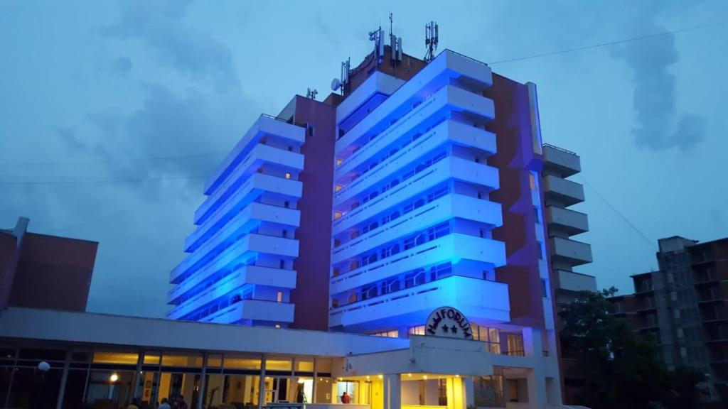 un edificio con luces azules encima en Hotel Forum, en Costinesti