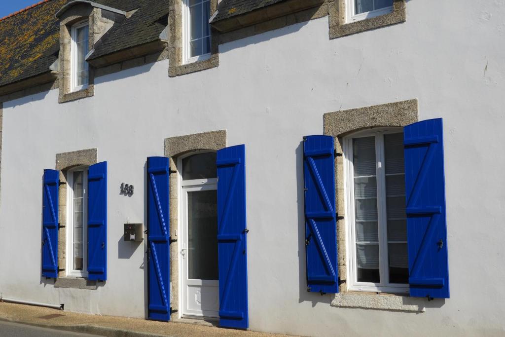 a building with blue shutters and windows at les volets bleus in Saint-Guénolé
