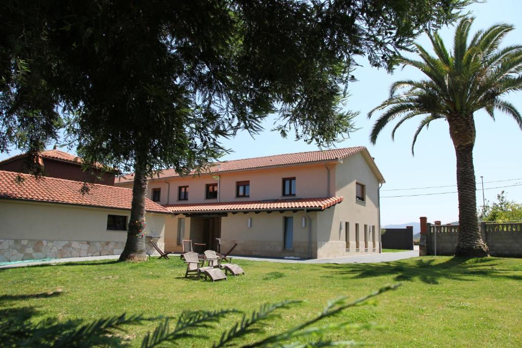 een huis met twee palmbomen ervoor bij Casa Carmina Hostel in Muros de Nalón