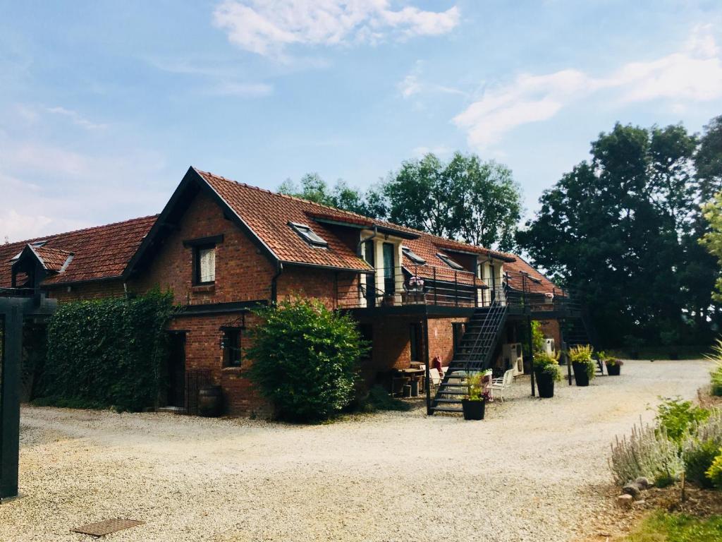 a large brick house with a porch and a balcony at La Niche in Richebourg