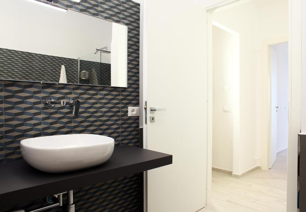 łazienka z białą umywalką i lustrem w obiekcie Sea Windows Suite w Trapani