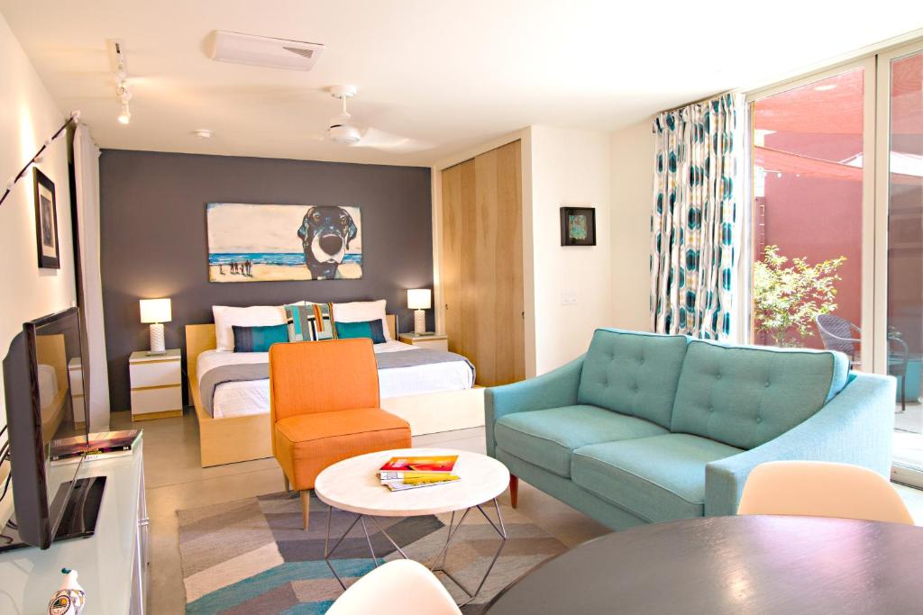 a hotel room with a bedroom and a bed and a couch at Modern Casita in Historic Downtown Albuquerque in Albuquerque
