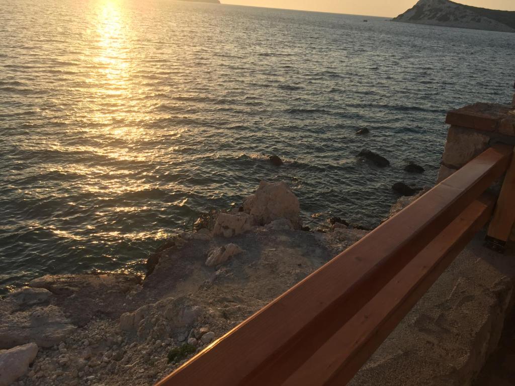 a view of a body of water with the sun setting at Teras butik apart in Karaburun