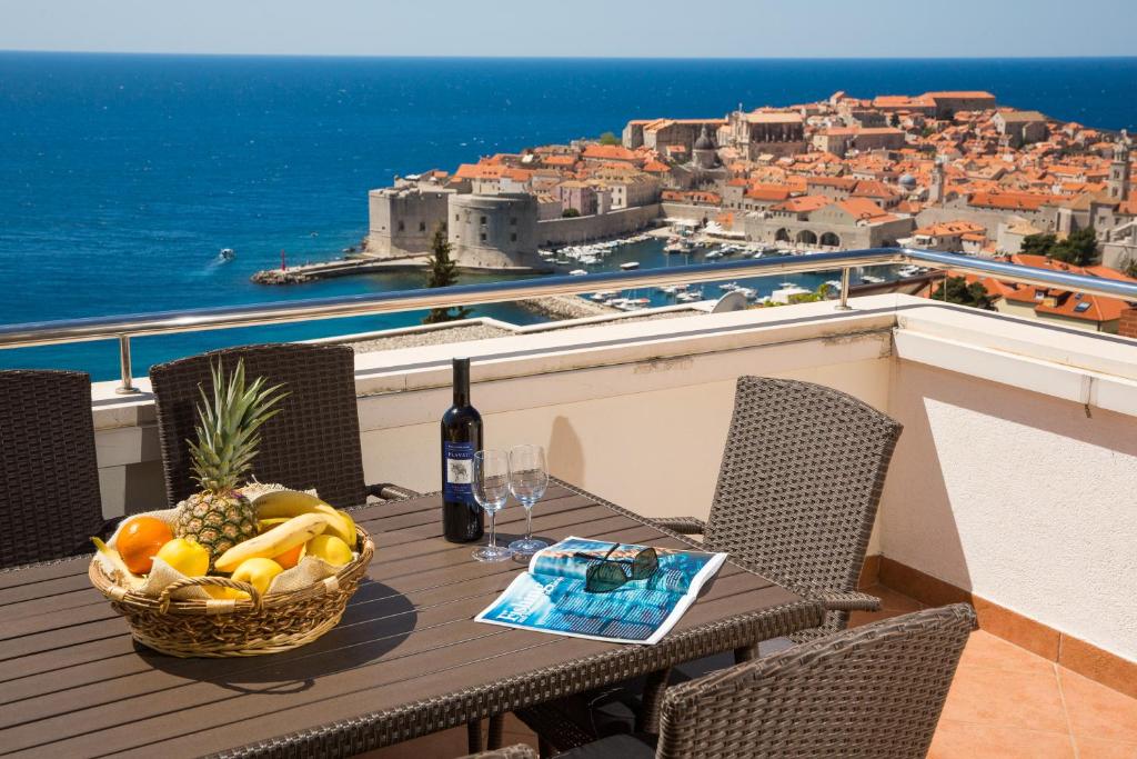 a table with a basket of fruit on a balcony at Penthouse Fantasia in Dubrovnik