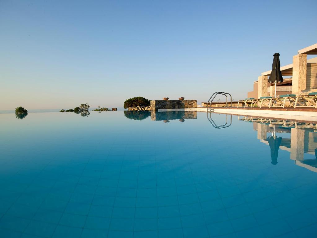 una piscina con acqua blu accanto a un resort di Kakkos Beach Hotel - Adults Only a Ierápetra