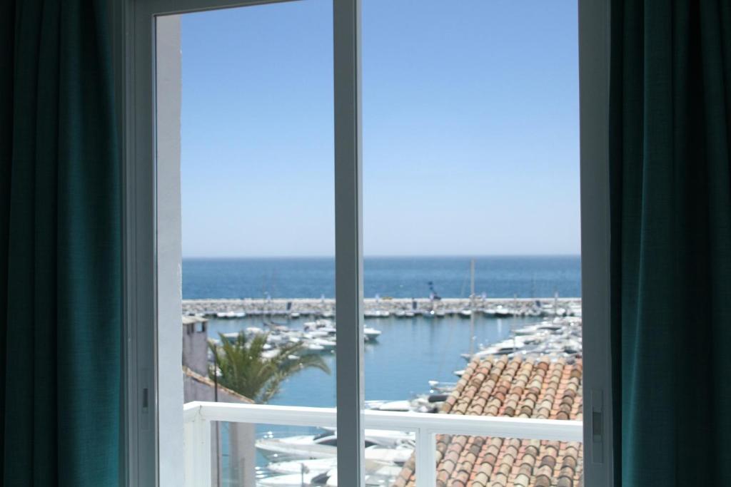 una ventana del hotel con vistas al puerto deportivo en Luxury Holiday Apartment in Puerto Banus Marina with sea views en Marbella