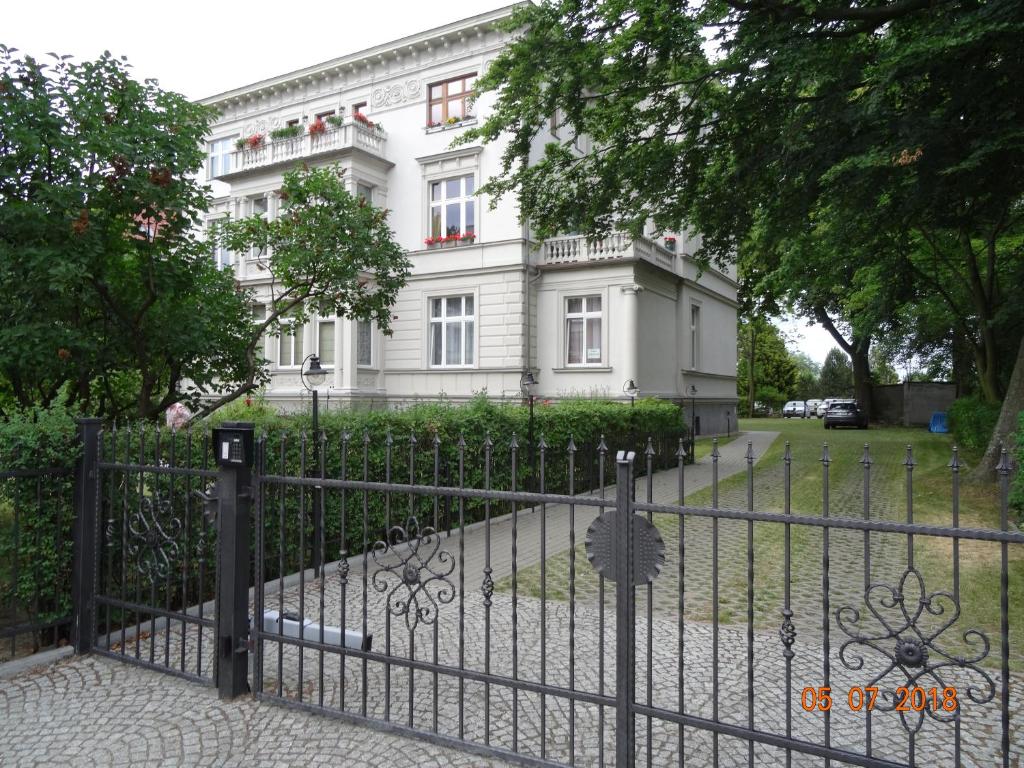 ソポトにあるSopot: apartament closest to the seaの白い建物の前の黒い柵