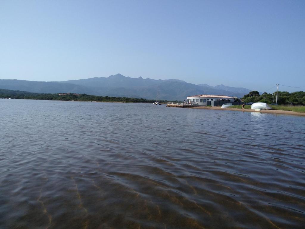 une grande étendue d'eau avec des montagnes en arrière-plan dans l'établissement Le Golfe, à Figari