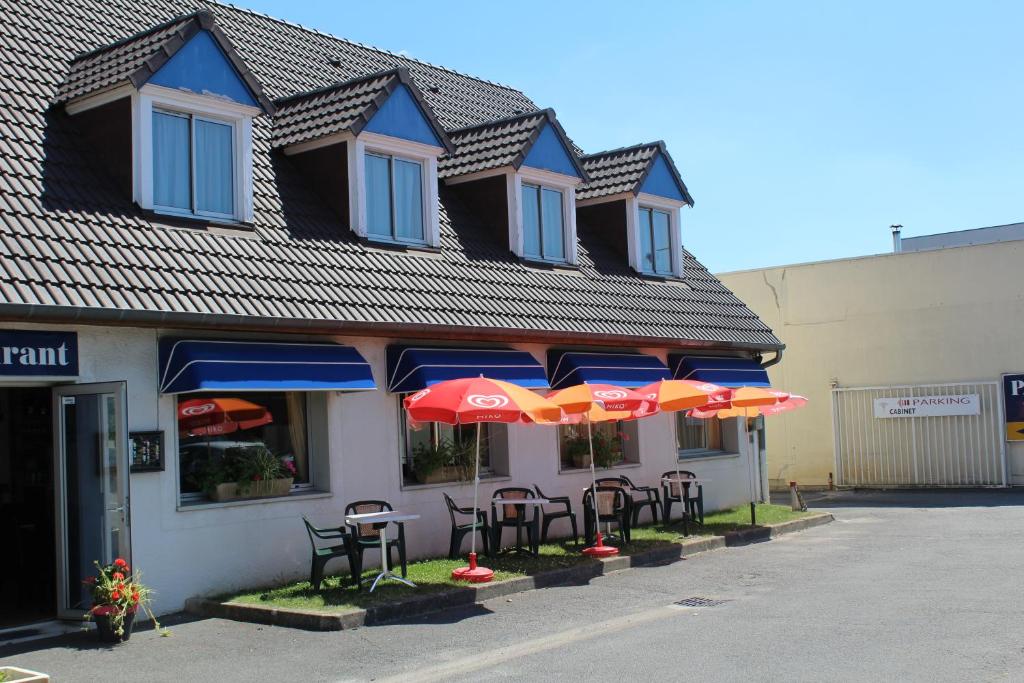 un grupo de mesas y sombrillas fuera de un edificio en HOTEL Chateau-Thierry Centre, en Château-Thierry