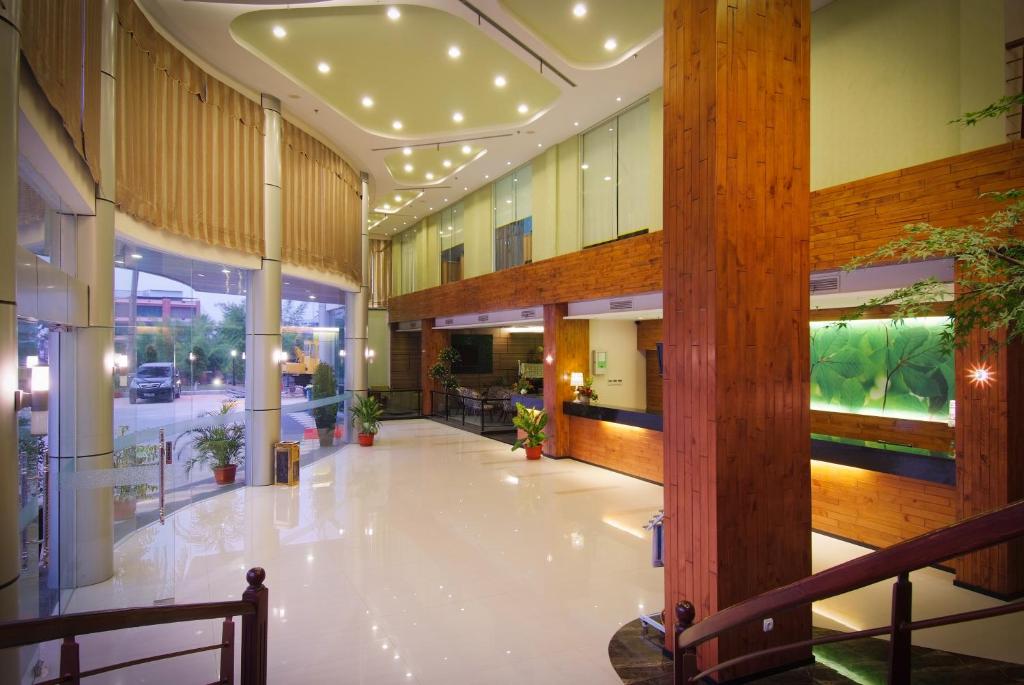 a lobby of a building with a hallway with plants at Angkasa Garden Hotel in Pekanbaru