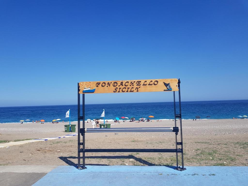 uma placa numa praia com a praia ao fundo em la corte al mare em Mascali