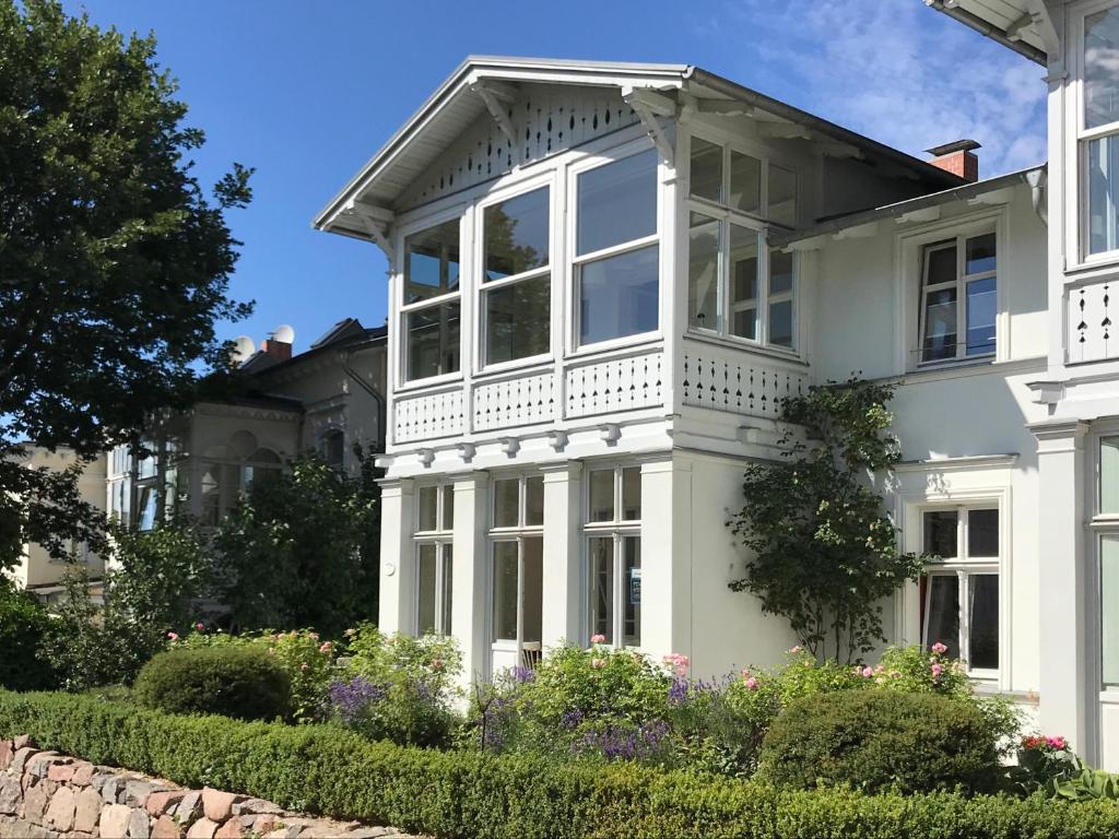 a white house with white windows and bushes at Alte Buchdruckerei in Heringsdorf