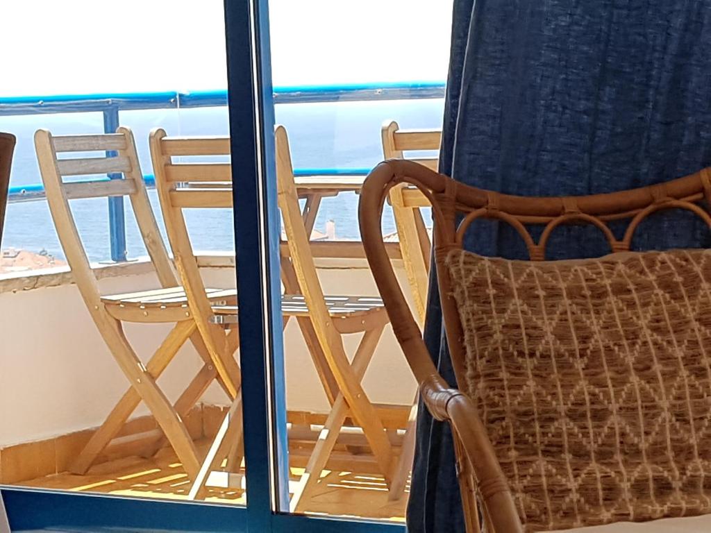 a chair sitting in front of a window at Apartamento Mar Salgado Ericeira in Ericeira