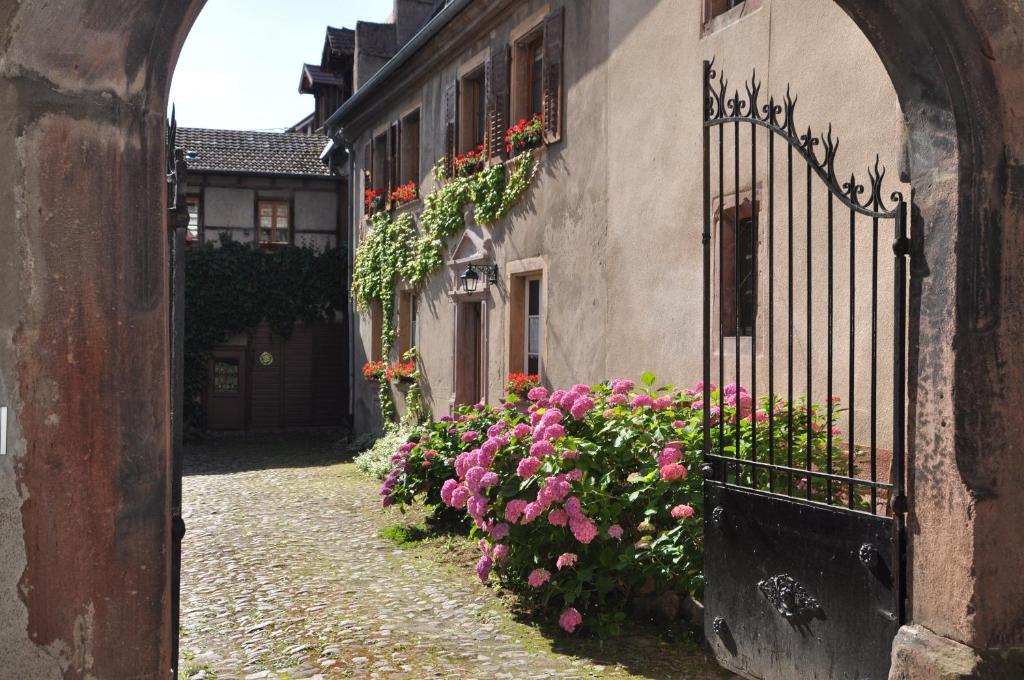 リクヴィールにあるLes Hortensiasの門付き建物の隣の花の小路