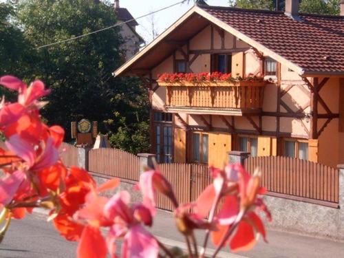 a building with a balcony with flowers in front of it at Gite de la Streng in Ribeauvillé