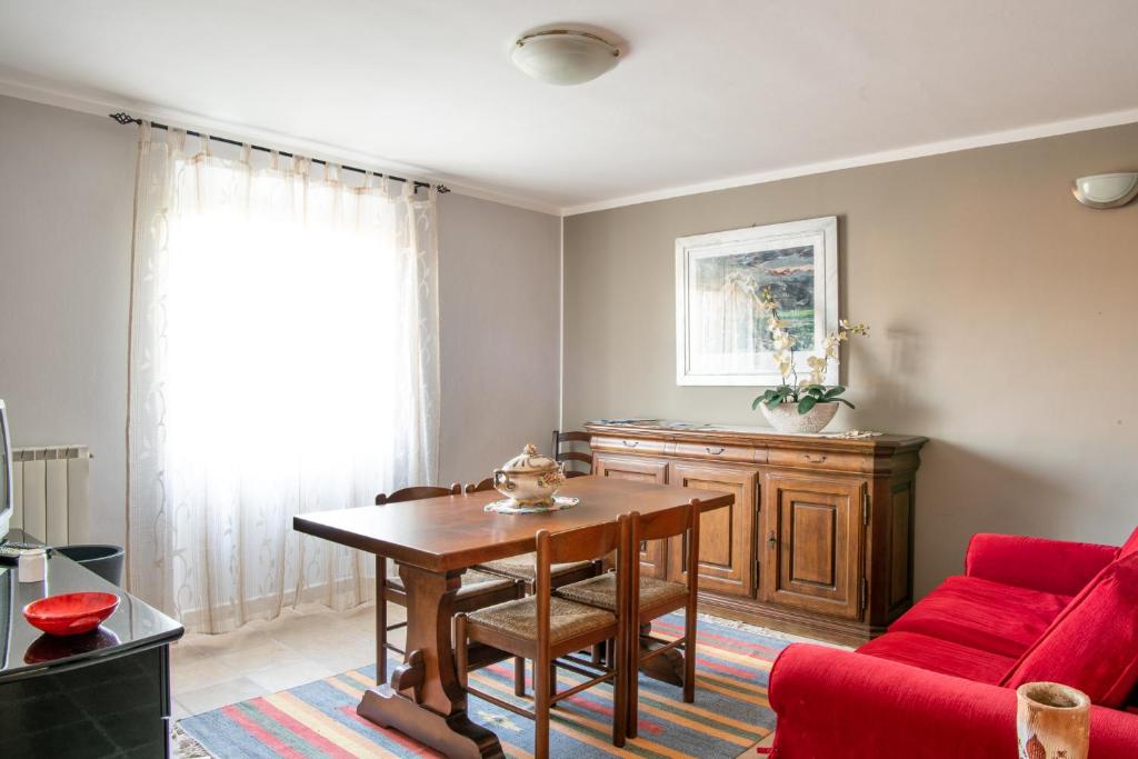 a living room with a table and a red couch at Casa Lidia in Scansano