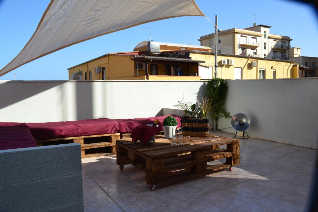 a patio with a couch and a table on a roof at Gocce Siciliane Apartments in Porto Empedocle