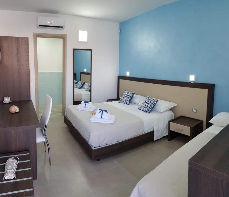 - une chambre avec un lit, un bureau et un miroir dans l'établissement Sole del Sud, à Torre San Giovanni