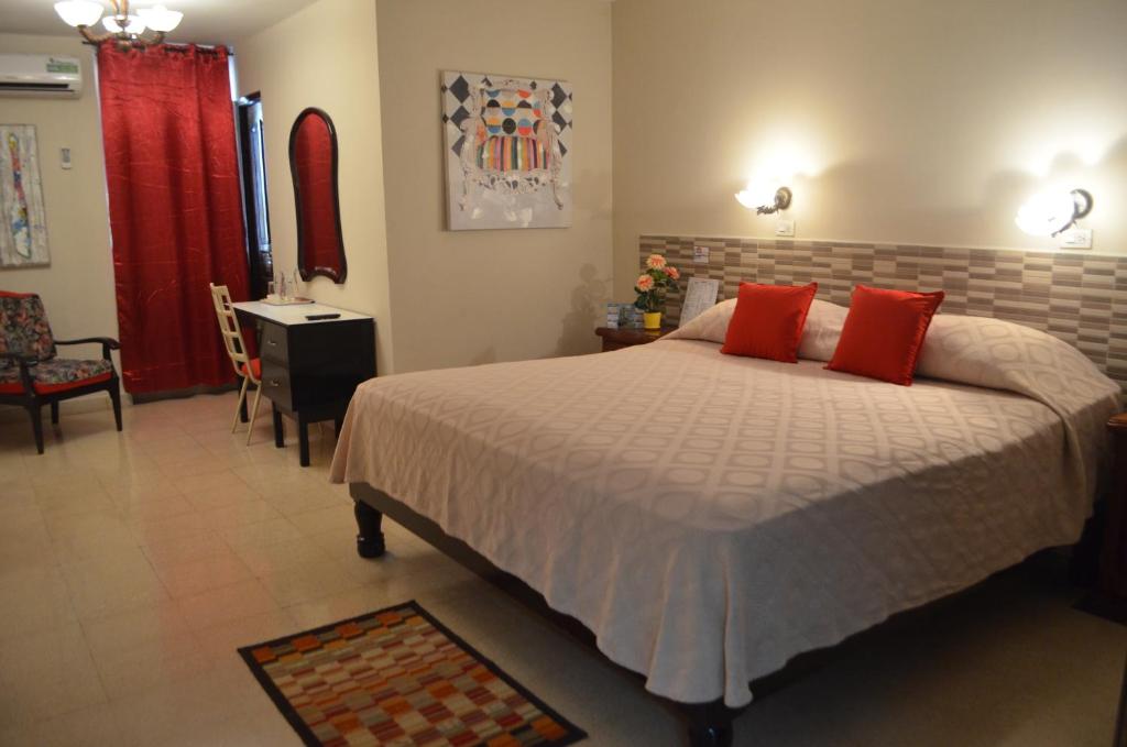 ein Schlafzimmer mit einem großen Bett mit roten Kissen in der Unterkunft Hotel Caribe Panamá in Panama-Stadt