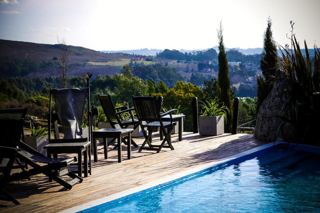 a group of chairs sitting next to a swimming pool at Elegance Hotel Tandil in Tandil
