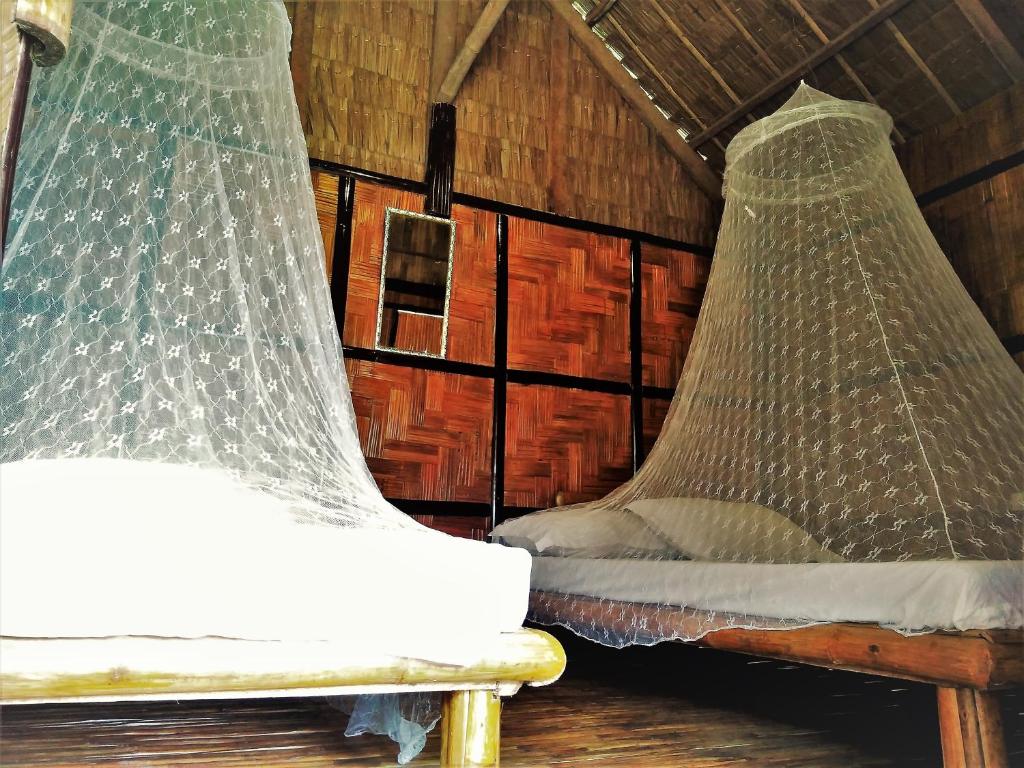 zwei Netze auf einem Bett in einem Zimmer in der Unterkunft Magindara Guesthouse in Caramoan