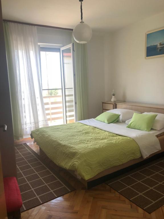 sypialnia z dużym łóżkiem i dużym oknem w obiekcie House For Holidays Kozul w Ražancu