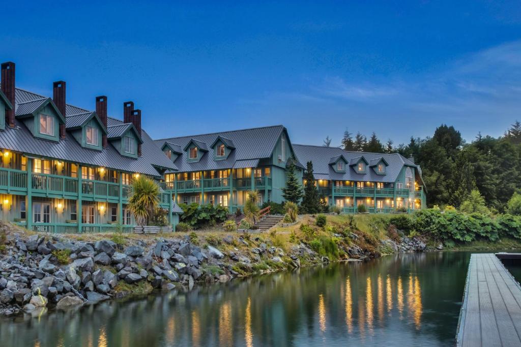 a large house with a river in front of it at Canadian Princess Lodge & Marina in Ucluelet