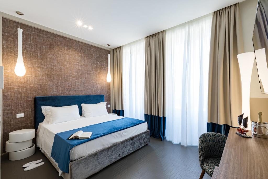 ローマにあるA World Aparts - Barberini Boutique Hotelのベッドとデスクが備わるホテルルームです。