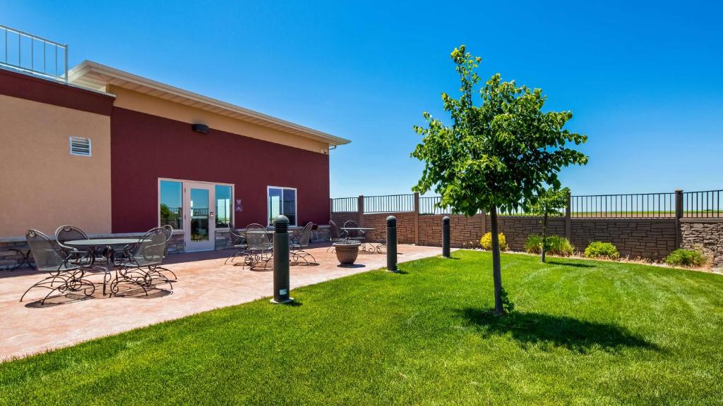 a patio with a table and a tree in a yard at Best Western Plus Carousel Inn & Suites Burlington in Burlington