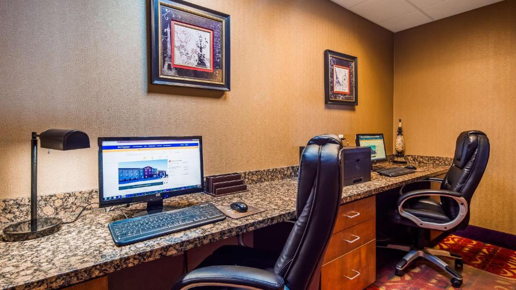 an office with a computer on a desk with chairs at Best Western Plus Carousel Inn & Suites Burlington in Burlington