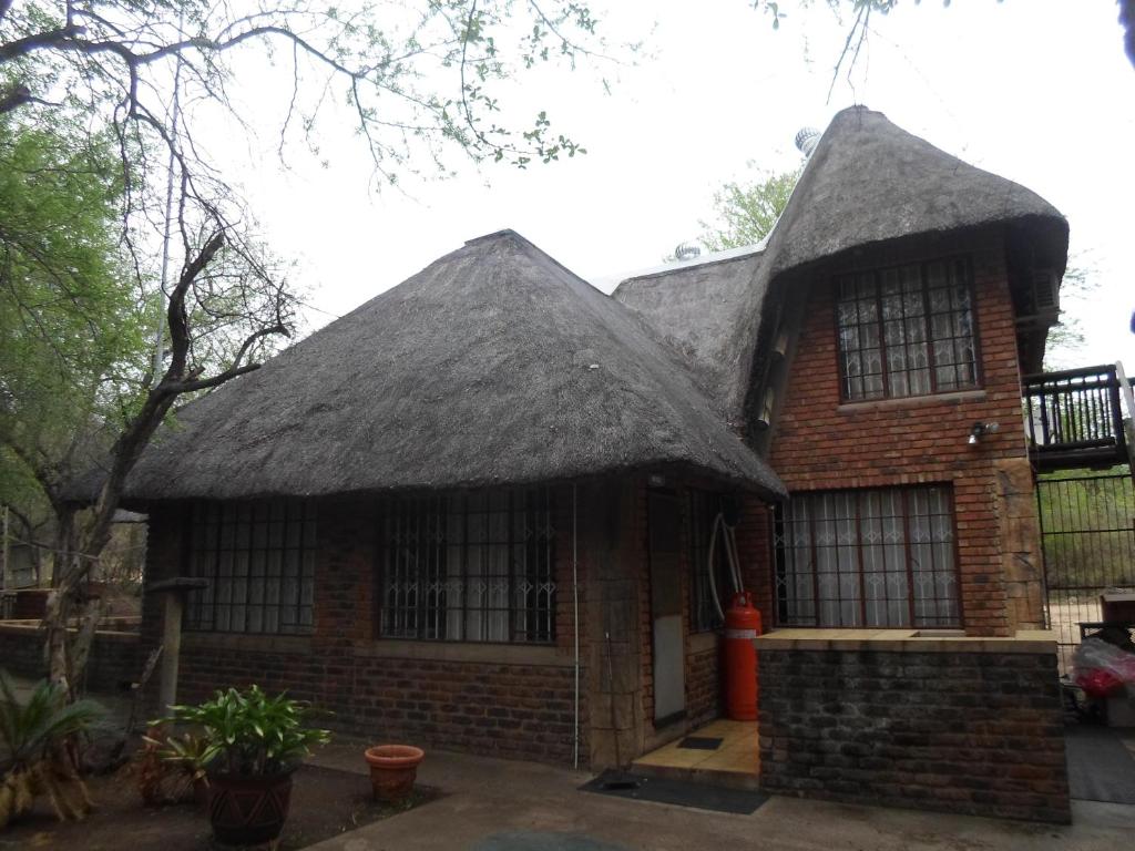 a large brick house with a thatched roof at Marloth Havens in Malelane