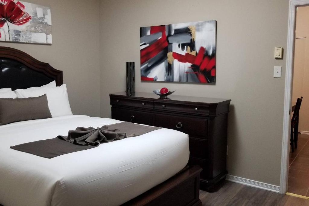 1 dormitorio con 1 cama con tocador y una pintura en Sweet 2-Bedroom Penthouse Apartment by Amazing Property Rentals, en Gatineau