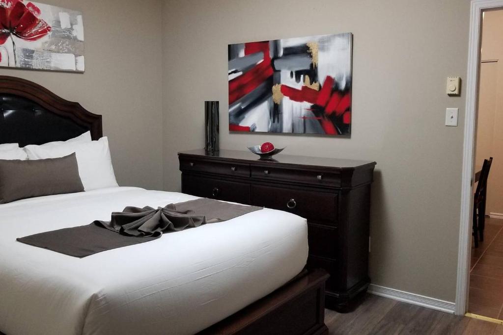 a bedroom with a bed with a dresser and a painting at Sweet 2-Bedroom Penthouse Apartment by Amazing Property Rentals in Gatineau