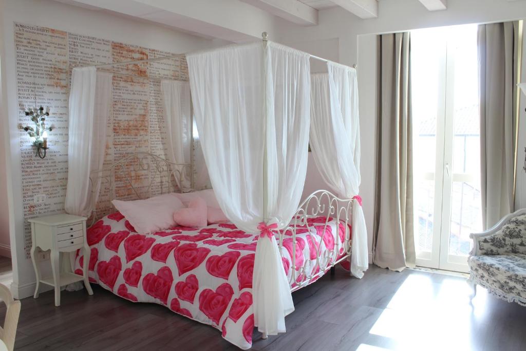 um quarto com uma cama vermelha e branca com cortinas em Angels'Home em Pizzo