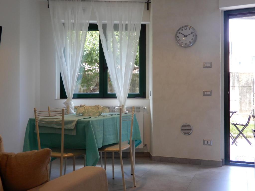 uma sala de jantar com mesa e cadeiras e um relógio em casa vacanze luciano&son em Campobasso