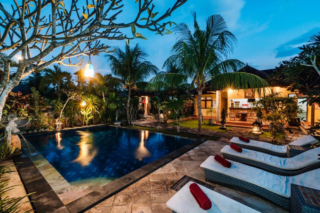 a pool with lounge chairs next to a house at Bunda 7 Bungalows in Nusa Lembongan