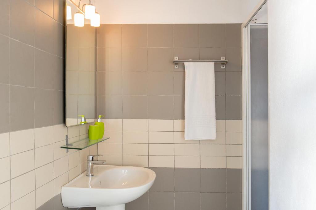 łazienka z umywalką i lustrem w obiekcie Aura Marina Apartments Santorini w Akrotiri