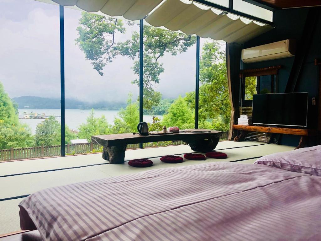 a bedroom with a bed and a large window at Yue Lake Backpackers in Yuchi