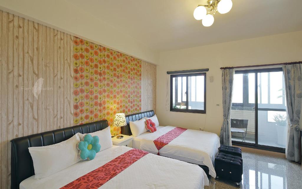 a bedroom with two beds and a window at Fish House Hostel in Wujie