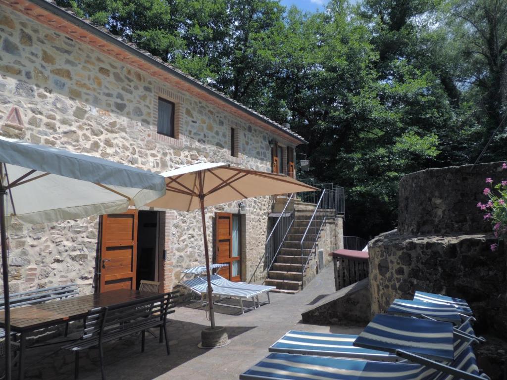 阿爾奇多索的住宿－Agriturismo Molino del Ponte，一座带椅子和遮阳伞的庭院以及一座建筑