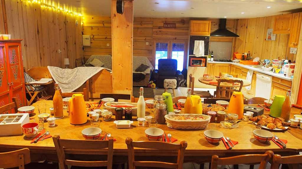 a kitchen with a large wooden table with food on it at Yourtes Olachat proche Annecy in Faverges