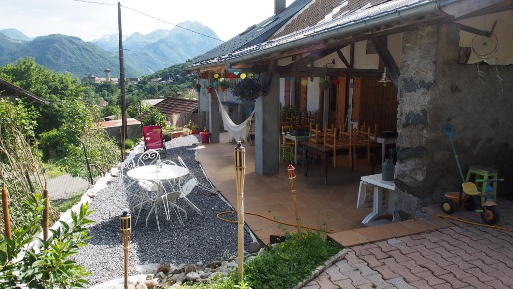 a patio of a house with a table and chairs at Yourtes Olachat proche Annecy in Faverges