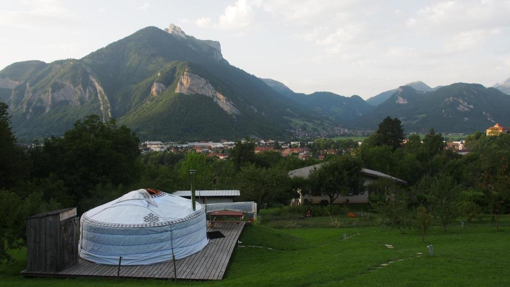 a large dome on a building with mountains in the background at Yourtes Olachat proche Annecy in Faverges