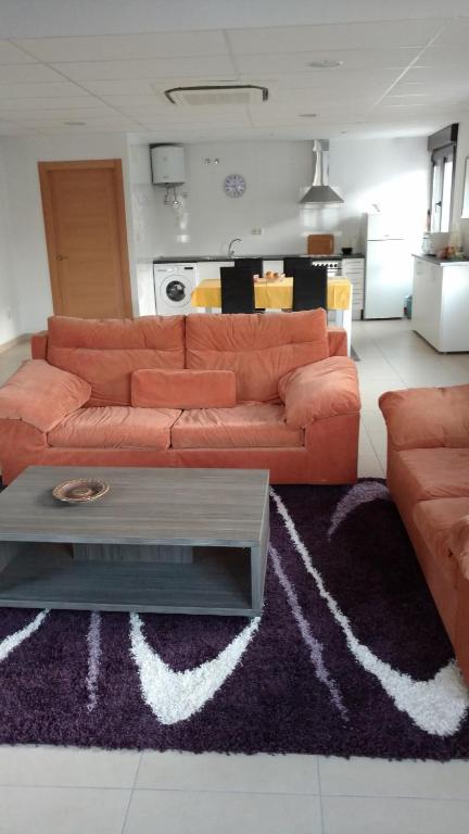 a living room with a orange couch and a rug at apartamento la carrera in Mondaria
