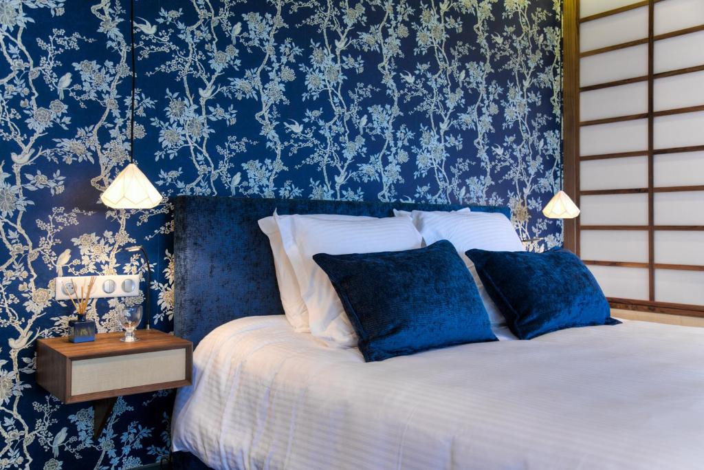 a bedroom with blue and white wallpaper and a bed at Chambres d'hôtes Domaine de Nazère in Avezan