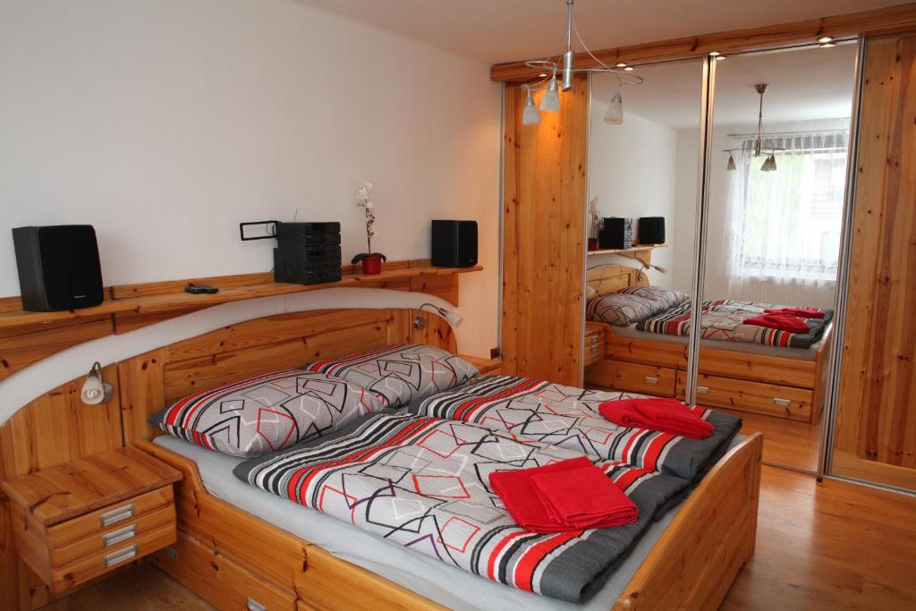 una camera da letto con un grande letto in legno con cuscini rossi di Dům v Českém ráji a Dolní Bousov