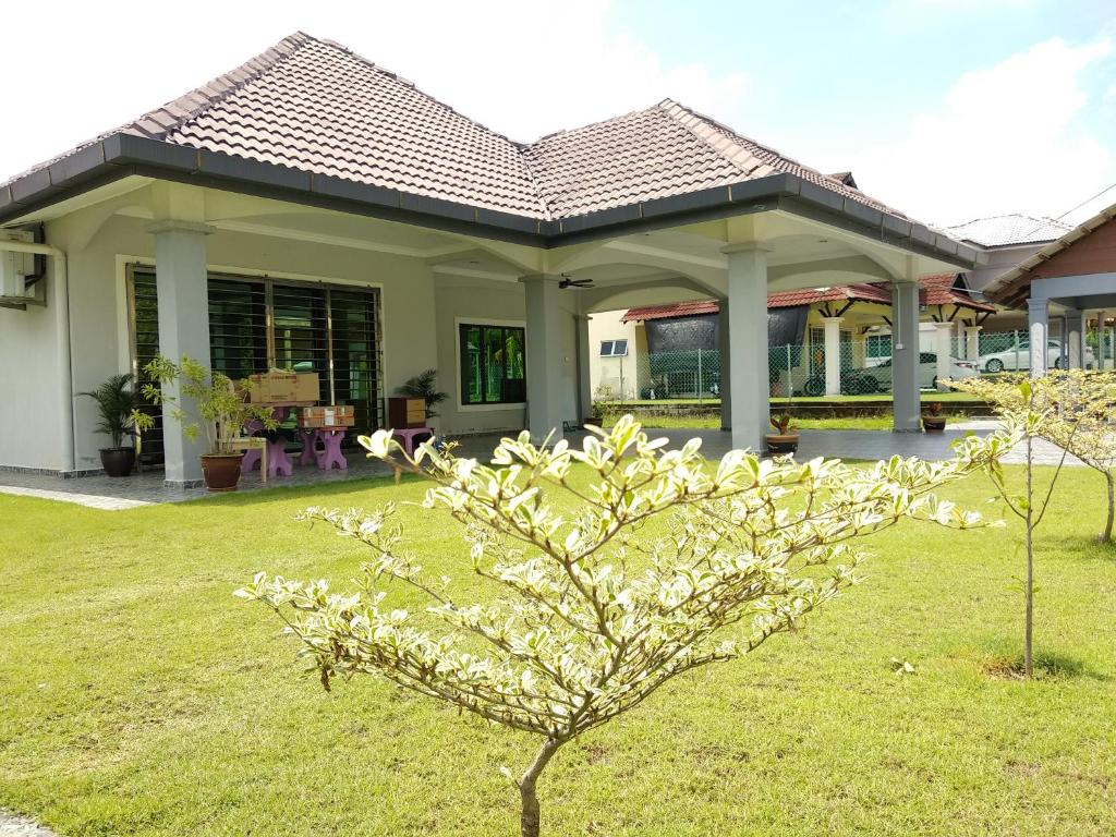 un petit arbre dans une cour devant une maison dans l'établissement Lot 4 PD Villa, à Port Dickson