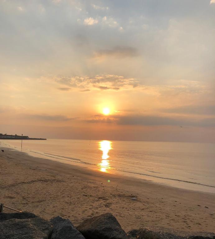 a sunset on a beach with the sun setting at Garden Oasis in Margate