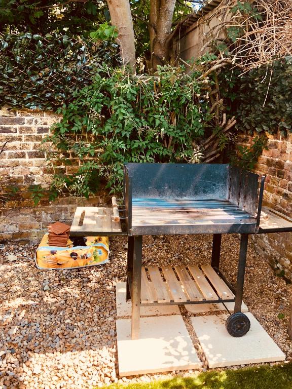 a blue bench sitting in front of a brick wall at Garden Oasis in Margate